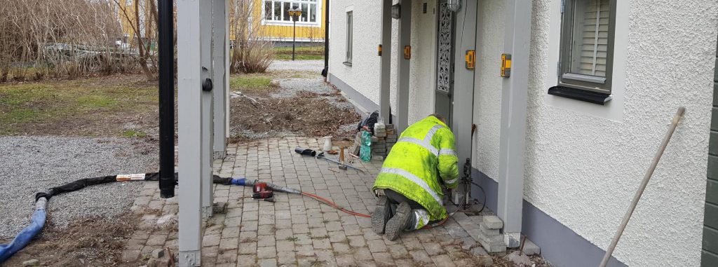 En bild på en anställd som grundstabiliserar en sättningsskada i en husgrund